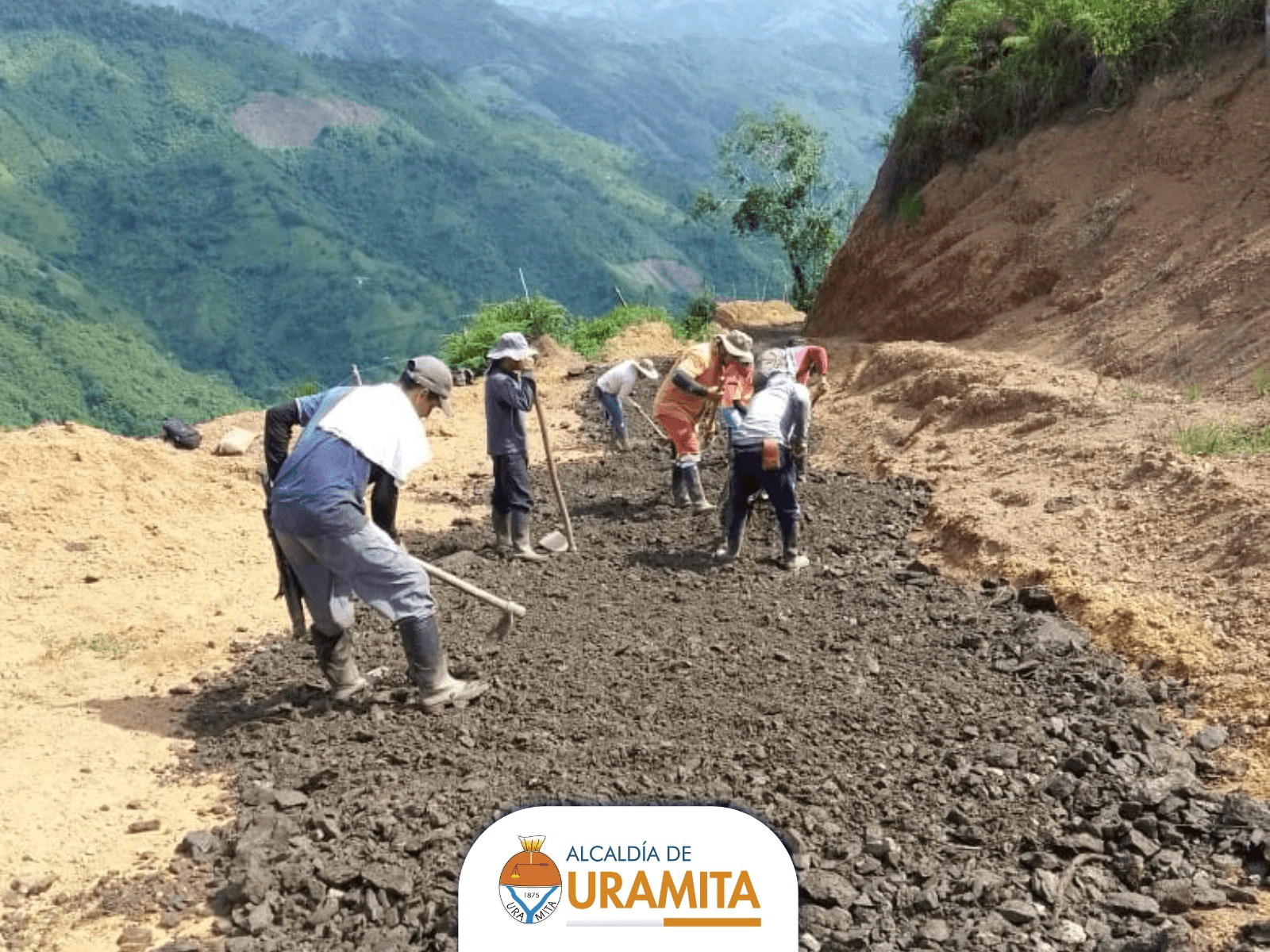 Construcción de vía terciaria Vereda Guayabal - Trabajadores esparciendo material de afirmado en la montaña, Uramita
